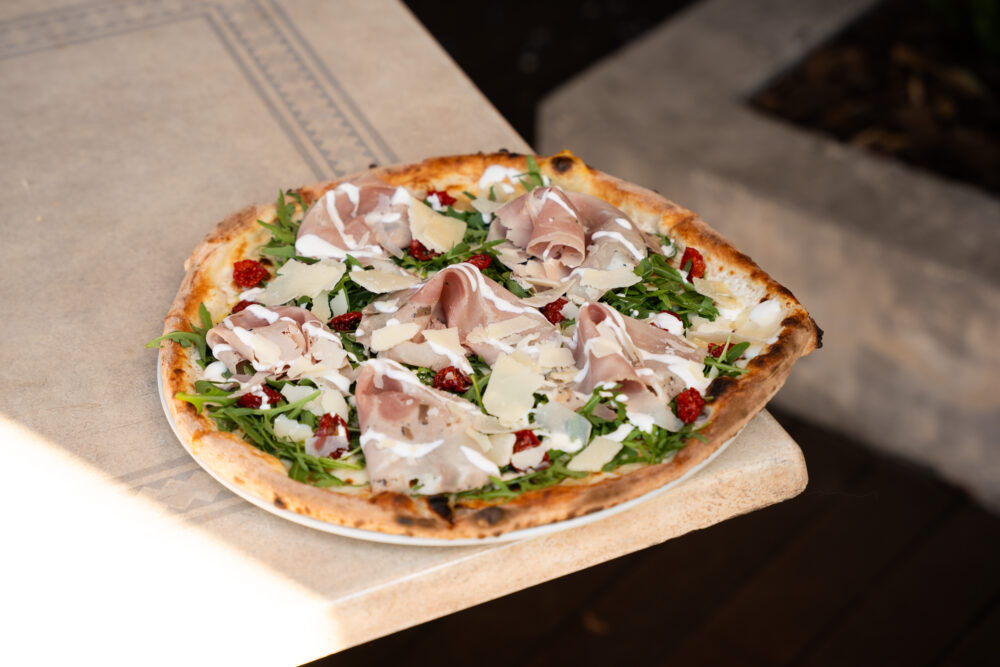 Pizza Sole del Sud - burrata krém, mozzarella, szarvasgombás cotto sonka, parmezán, rukkola, aszalt paradicsom -